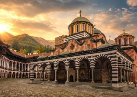 Rila Monastery, one of the top things to do in Bulgaria, framed by mountains at golden hour